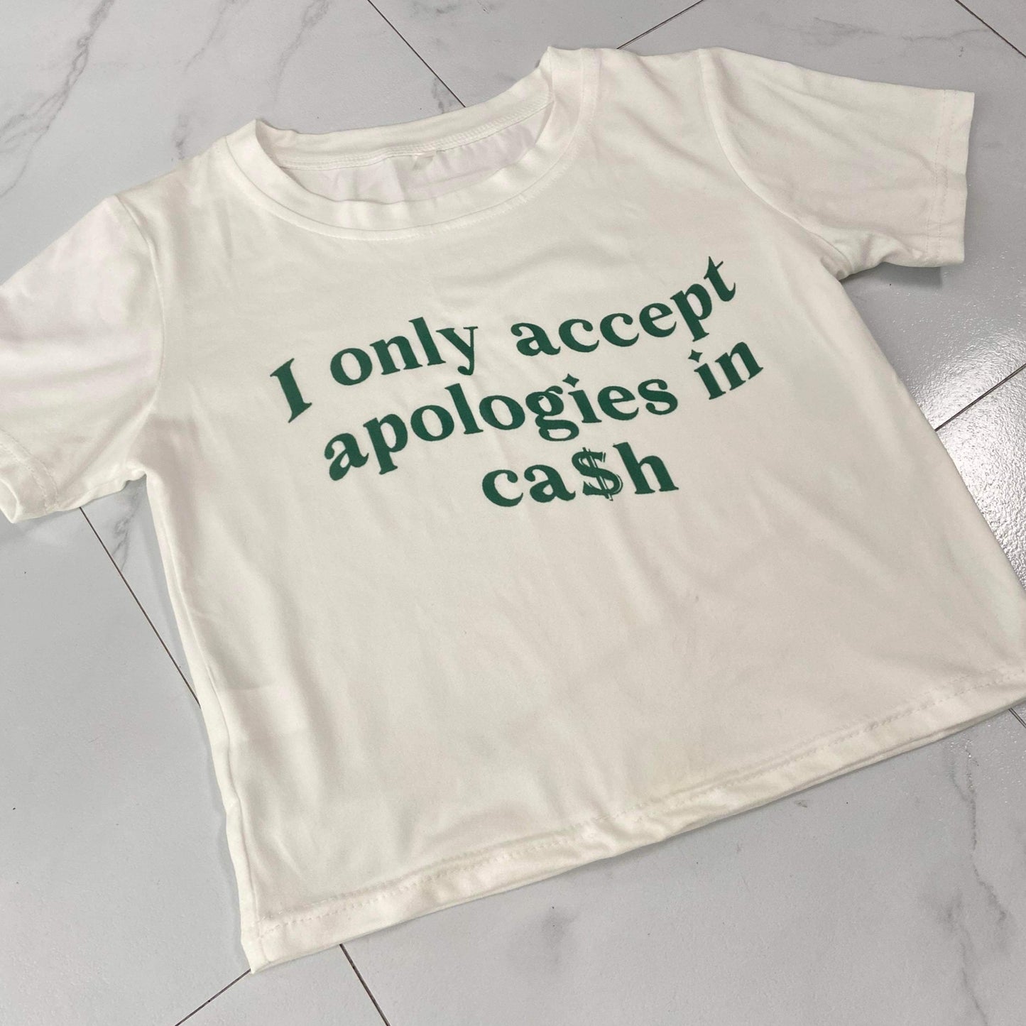 Women's Cash Apologies Graphic Crop Top- BaeBekillinem Boutique- White/ Green- baby tee- Cotton- Casual- graphic- it girl- Megan the stallion- city girls- Yung miami- jt- Nicki minaj- party- club- girls night